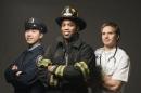 A photo of three first responders: An emergency medical technician, 一名消防员, 还有一个警察